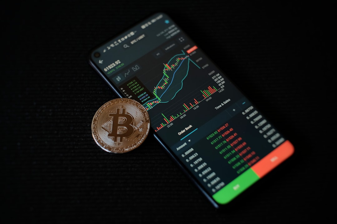 a-bitcoin-sitting-on-top-of-a-smart-phone-b-qyiqltif0
